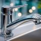 modern chrome kitchen water faucet installed in stainless steel sink photo